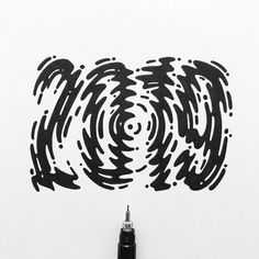 an ink pen drawing the shape of a spiral