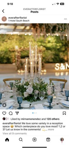 the table is set with blue and white plates, silverware, candles and flowers