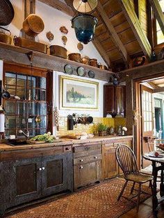 an old fashioned kitchen with lots of wooden cabinets and hanging pots on the wall above the stove