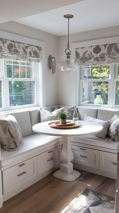 a kitchen with white cabinets and lots of counter space, including a round table in the center