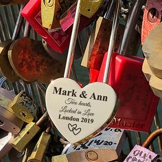 a bunch of locks that are attached to a fence with the names of their loved ones