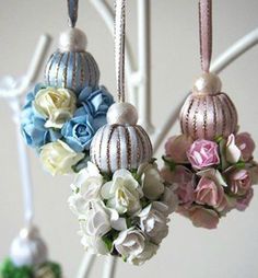 three ornaments hanging from a tree with flowers