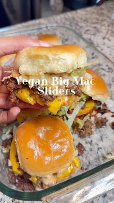 a person holding a hamburger in their left hand with the words vegan big mac sliders on it