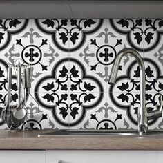 a kitchen with black and white tile backsplash, stainless steel faucets and wooden counter tops