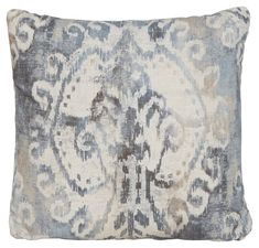 a blue and white pillow with an ornate design on the front, sitting on a white background