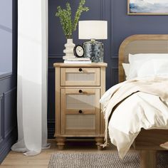 a bedroom scene with focus on the bed, nightstand and night stand in the foreground