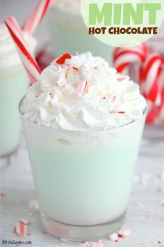 two glasses filled with whipped cream and peppermint candy canes on the side