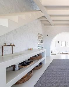 a room with white walls and carpeted flooring next to a shelf filled with shoes