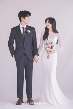 a man and woman in formal wear standing next to each other with their hands together