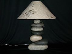 a lamp that is sitting on top of some rocks and has a shade over it