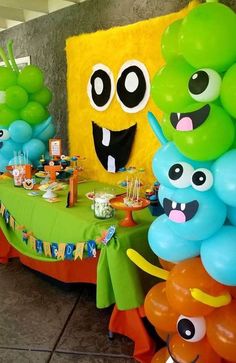 a table with balloons and decorations for a monster themed birthday party at a children's party