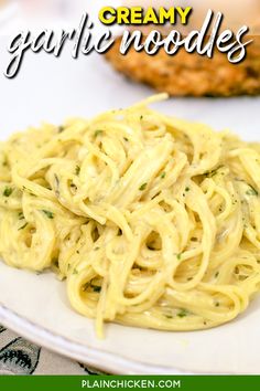 creamy garlic noodles with homemade pesto sauce on a white plate next to grilled chicken