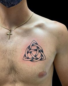 a man with a cross tattoo on his chest