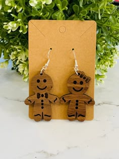 the wooden earrings are shaped like two people