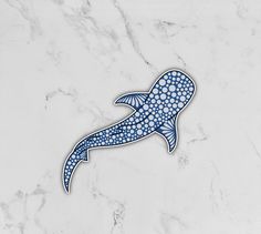 a sticker depicting a blue whale on a white marble surface with dots in the shape of a fish