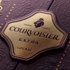 a close up of a label on a purple book with gold foil lettering and ornate designs