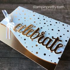 a white and gold card with the word celebrate written in cursive writing on it