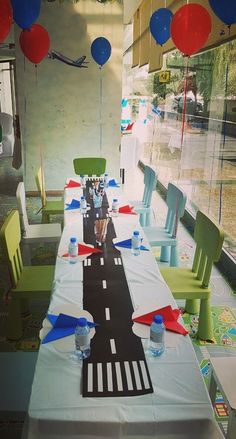 a long table set up with balloons and streamers