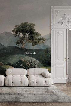 a white couch sitting in front of a wall with a painting on it's side