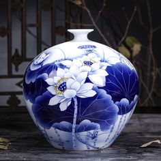 a blue and white vase sitting on top of a table next to a planter