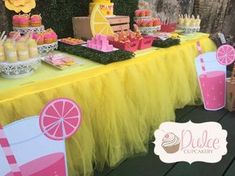 a table topped with pink and yellow desserts