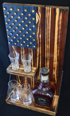 an american flag made out of wood with glasses on the bottom and one empty glass next to it