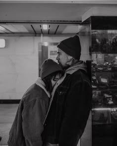 a man and woman standing next to each other in front of a glass display case