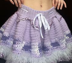 a close up of a person wearing a purple skirt with white trims on it