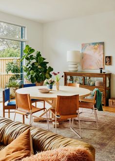 a living room filled with furniture and a large window covered in lots of greenery