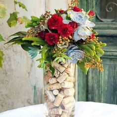 a vase filled with flowers and rocks on top of a table