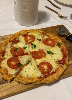 a pizza sitting on top of a wooden cutting board