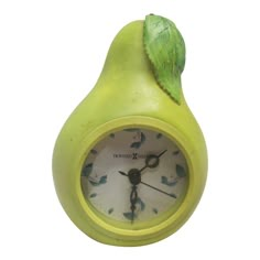 a pear shaped clock with a green leaf on it's top, against a white background