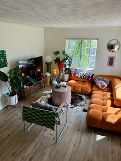 a living room filled with furniture and a flat screen tv on top of a wooden floor