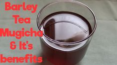 a glass filled with tea sitting on top of a table