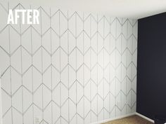 an empty room with white and black wallpaper