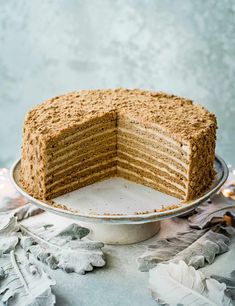 a cake that has been cut in half and is on a plate with leaves around it