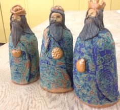 three ceramic figurines sitting on top of a table