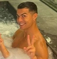 a man in a hot tub giving the peace sign