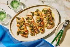 some food is on a white plate and next to two glasses with green liquids