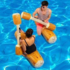 two women in swimsuits are sitting on rafts floating in a pool with blue water