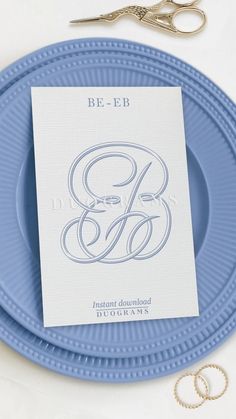 a blue plate with two wedding rings on it next to a pair of silver scissors