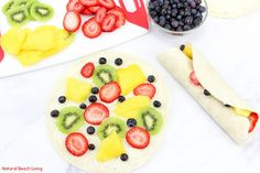 the fruit pizza is ready to be cut into slices and put on plates with other ingredients