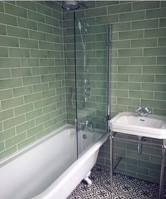 a white bath tub sitting next to a sink under a faucet in a bathroom