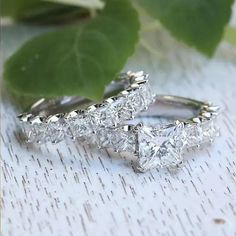 two wedding rings sitting on top of a table next to a green leafy plant