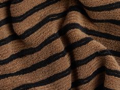 a close up view of a brown and black striped sweater with stripes on the fabric