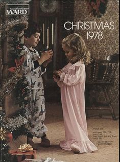 a young boy and girl dressed in pajamas standing next to a christmas tree with presents on it