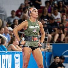 a woman standing in front of a crowd with her hands on her hips and looking up