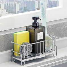 a toothbrush, soap and other items are sitting in a holder on the window sill