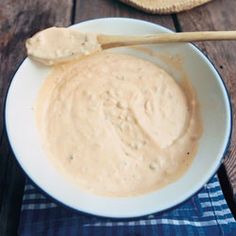 a white bowl filled with peanut butter on top of a blue and white checkered napkin