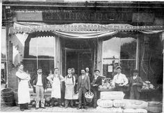 an old black and white photo of people standing in front of a store